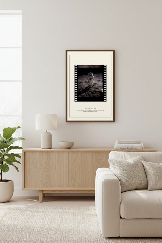 Framed Aldrin on the Moon photo above a light wood sideboard with a fiddle-leaf fig