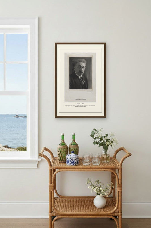 Einstein portrait print above a rattan bar cart near a coastal window view