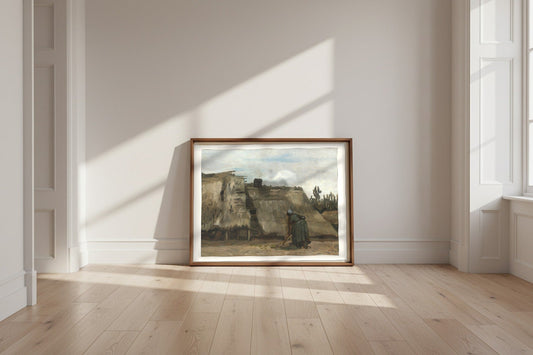 A Peasant Woman Digging in Front of Her Cottage — Vincent van Gogh Fine Art Poster shown framed and leaning against a wall in a sunlit room