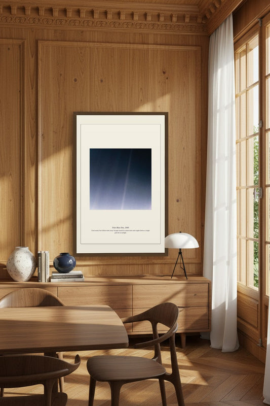 Pale Blue Dot print framed on wood-paneled wall in a dining room setting