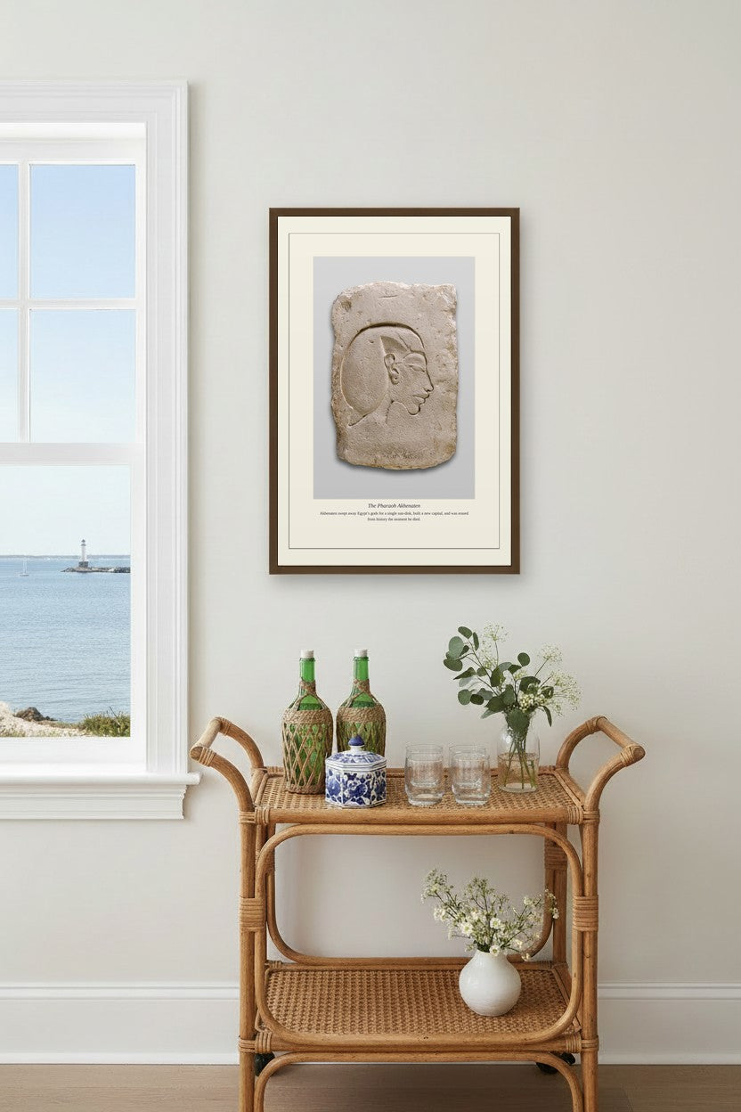The Pharaoh Akhenaten print framed above a rattan bar cart by a coastal window