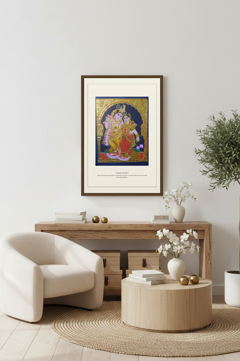 Tanjore Krishna gold-leaf print framed above a console with white armchair