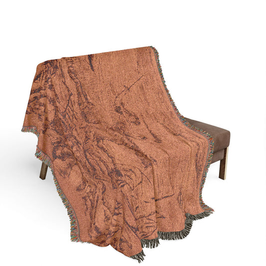The War woven throw blanket over bench, tan ground with historic battle scene figures and cavalry, fringe draping