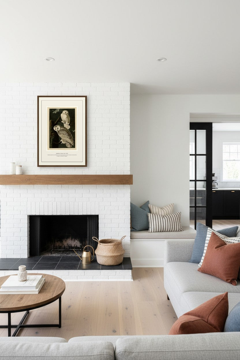 Snowy Owl print hung above a white brick fireplace mantel with a wood shelf