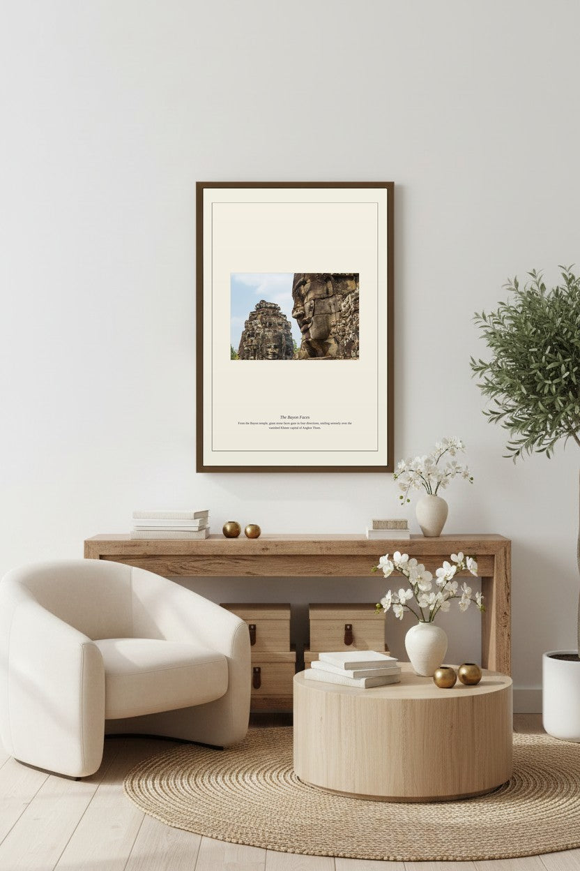 framed Bayon temple faces photograph above a wooden sideboard beside a cream armchair on a round rug