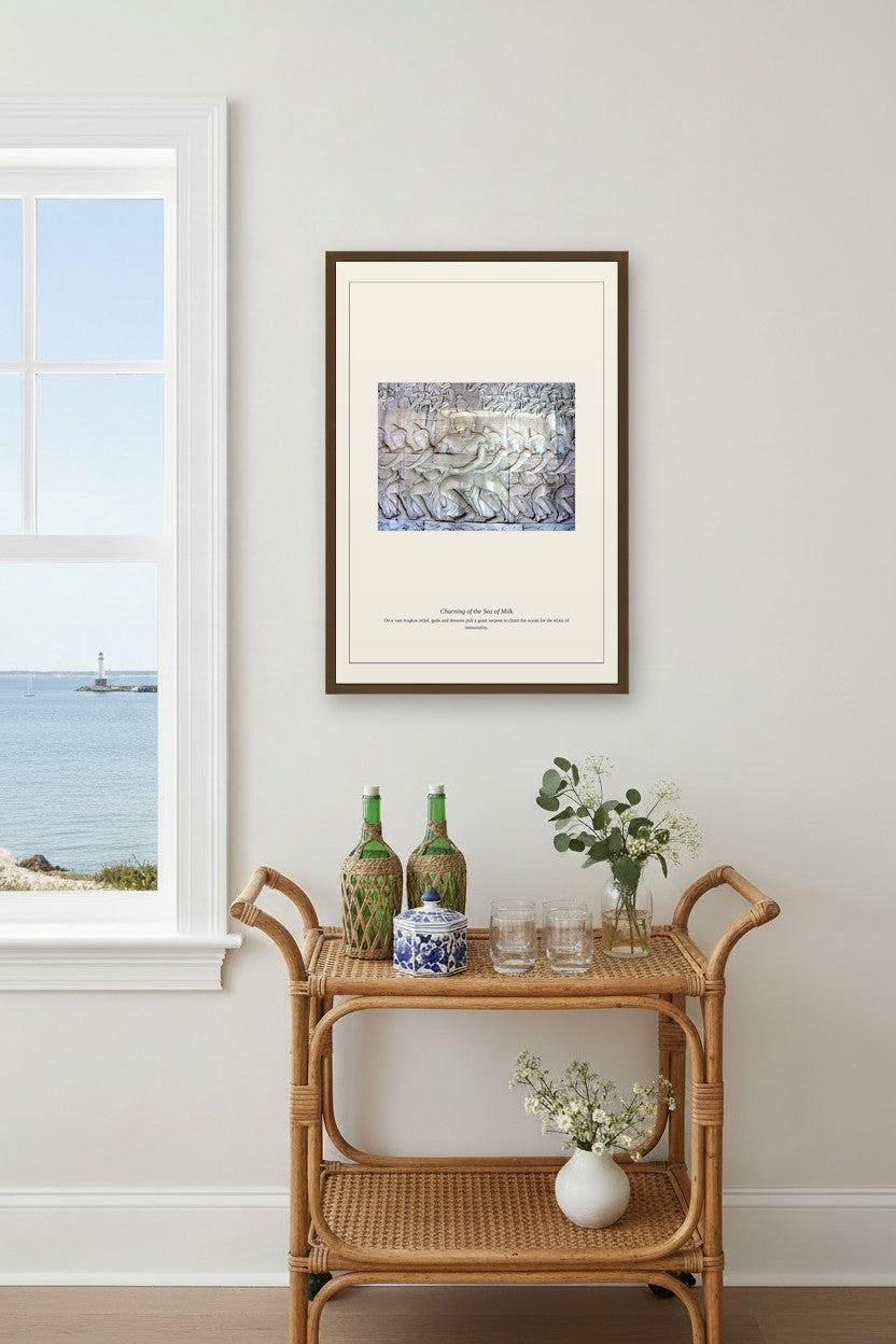 Churning of the Sea of Milk framed print above a rattan bar cart with glassware near a window overlooking the sea