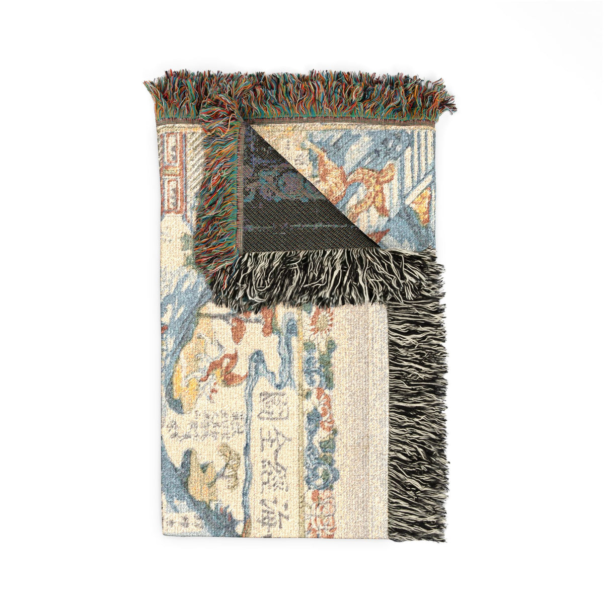Classic of Mountains and Seas throw blanket folded, cream front with dark charcoal reverse corner and colorful fringe detail