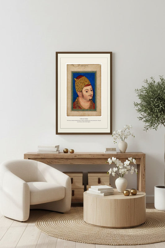 Framed Deccan Sultan portrait above a light wood sideboard beside a fiddle-leaf fig