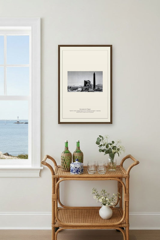 Egyptian obelisk engraving framed above a coastal bar cart with green bottles