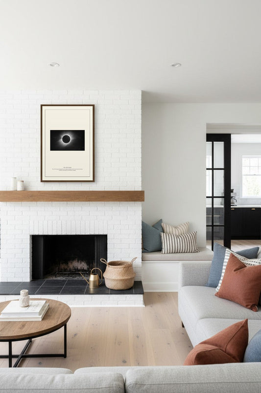 1919 Eclipse print above a white brick fireplace mantel with a wood shelf