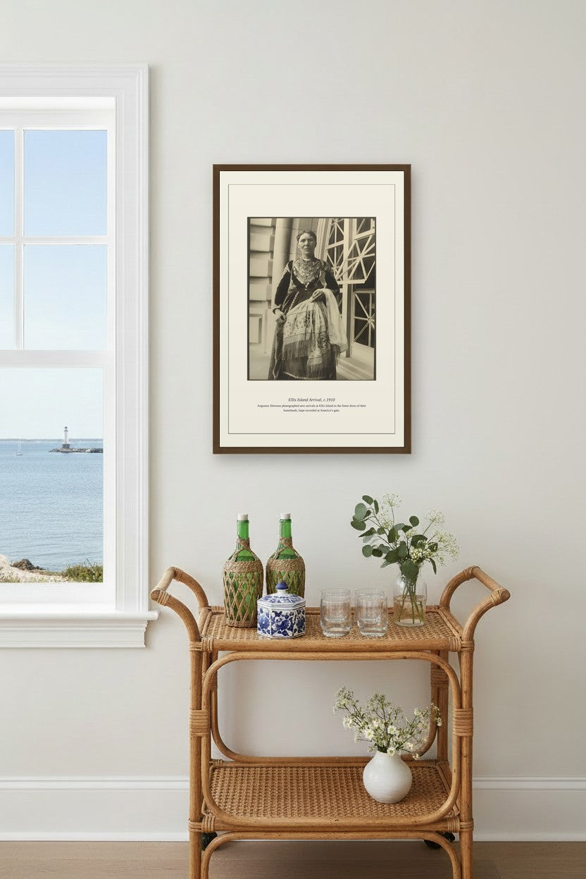 Ellis Island Arrival print framed above a rattan bar cart beside a coastal window