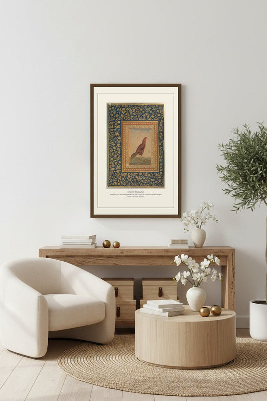 Framed Emperor Shah Jahan print above a wood console table with a bouclé chair and olive tree