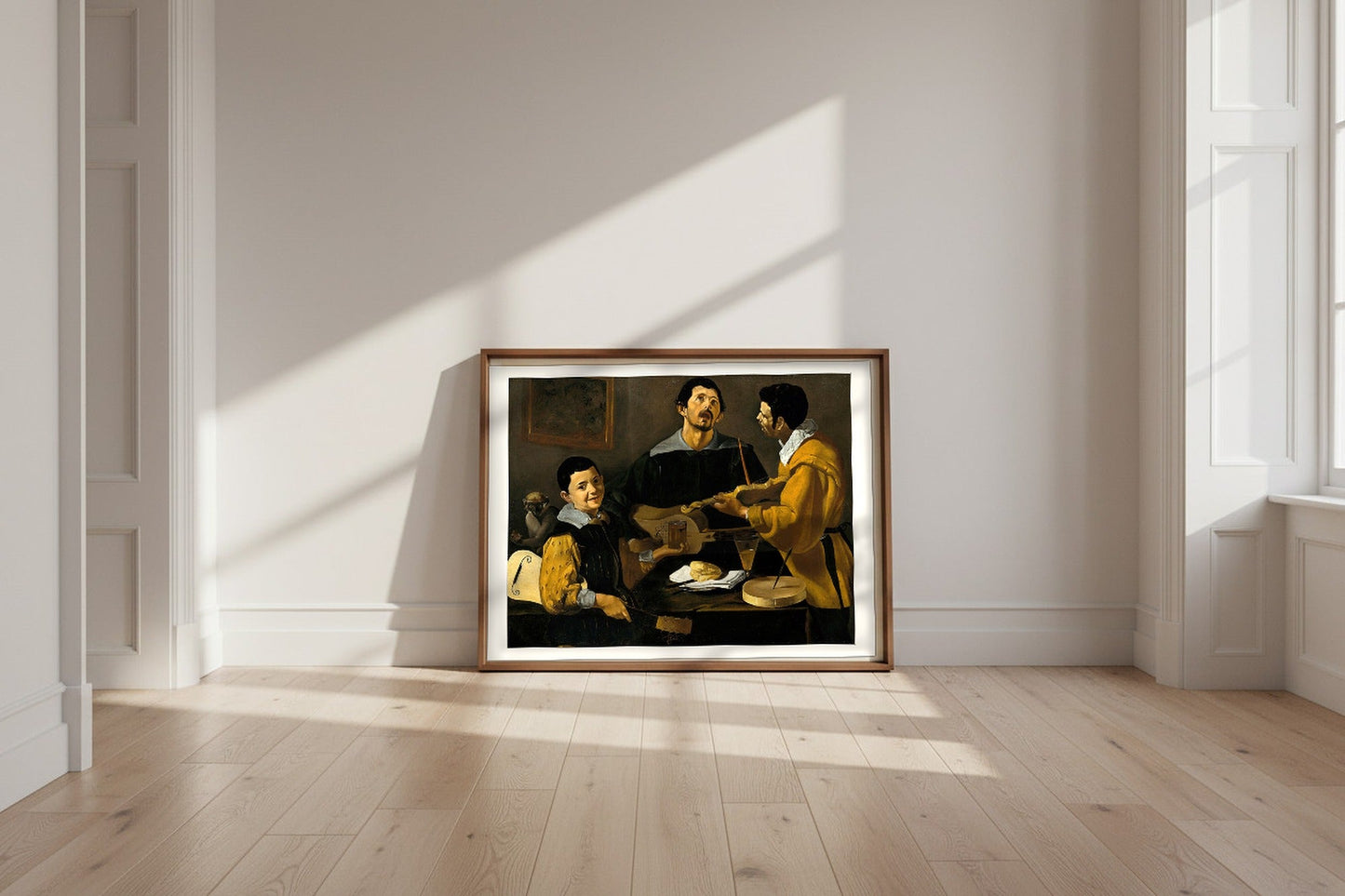The Three Musicians — Diego Velázquez Fine Art Poster shown framed and leaning against a wall in a sunlit room