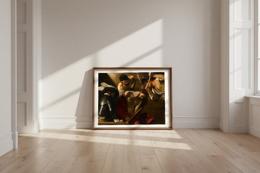The Crowning with Thorns — Caravaggio Fine Art Poster shown framed and leaning against a wall in a sunlit room