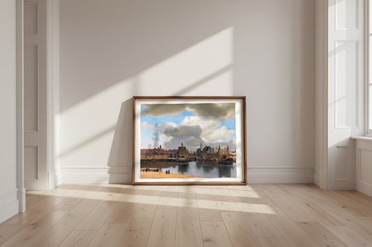 View of Delft — Johannes Vermeer Fine Art Poster shown framed and leaning against a wall in a sunlit room