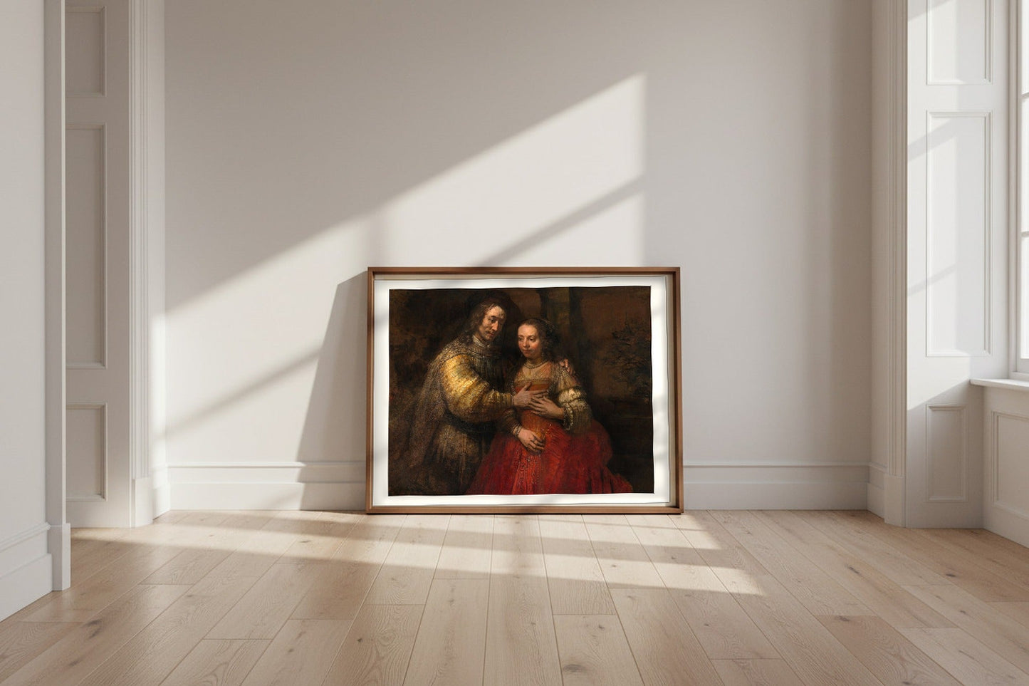 The Jewish Bride — Rembrandt van Rijn Fine Art Poster shown framed and leaning against a wall in a sunlit room