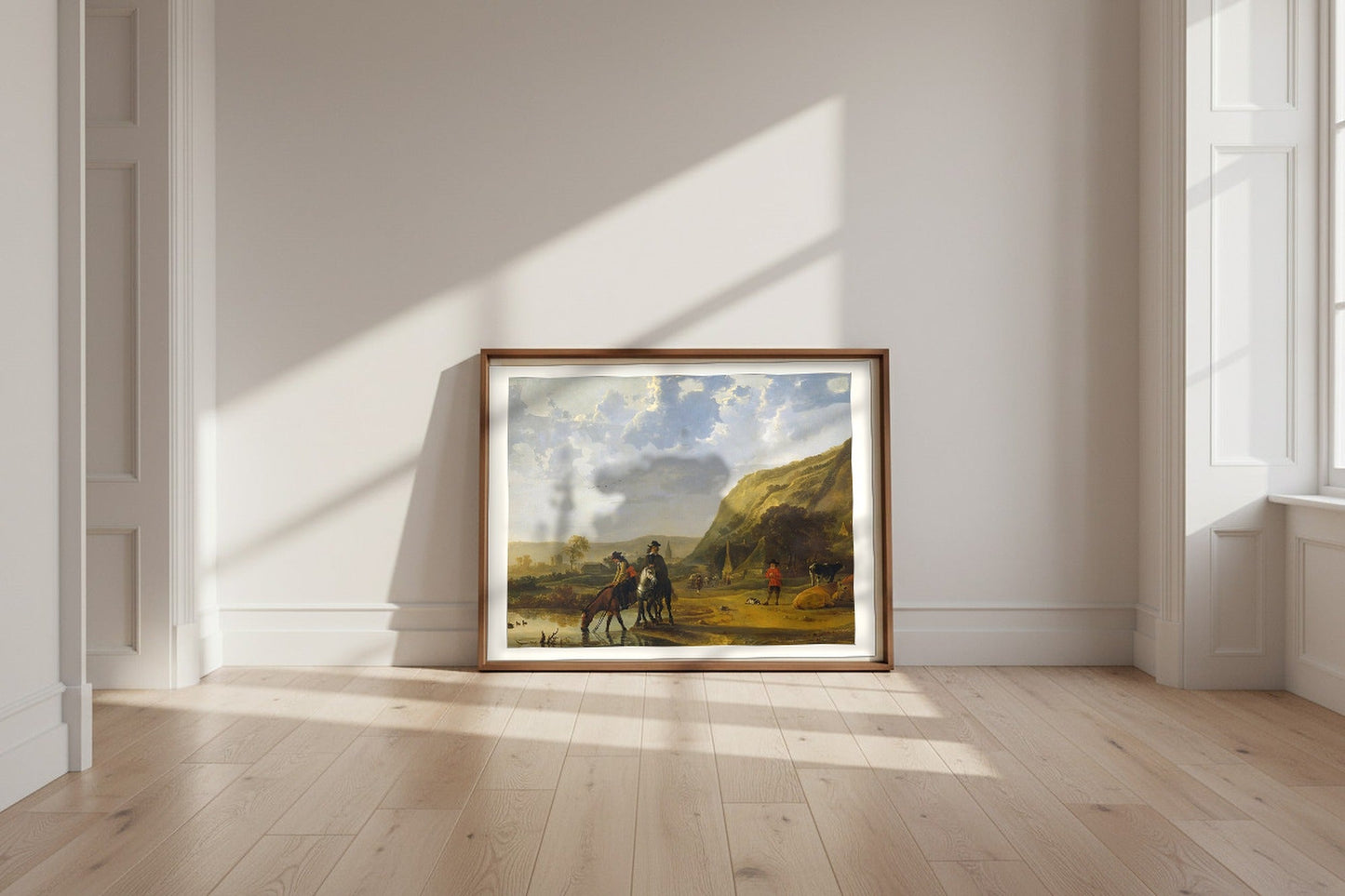 River Landscape with Horsemen — Aelbert Cuyp Fine Art Poster shown framed and leaning against a wall in a sunlit room