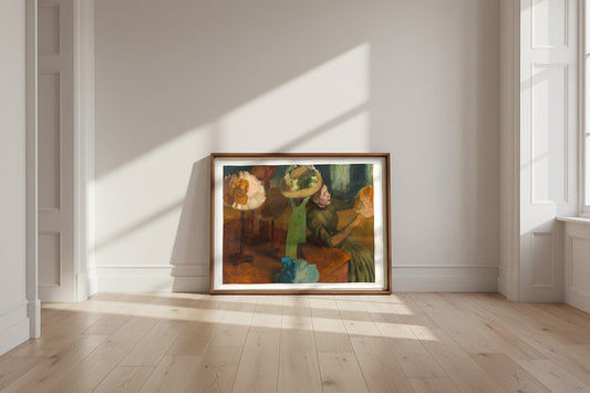 The Millinery Shop — Edgar Degas Fine Art Poster shown framed and leaning against a wall in a sunlit room