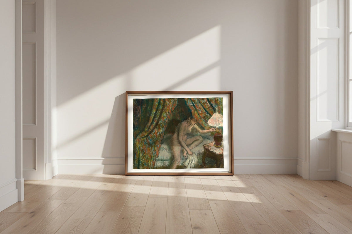Retiring — Edgar Degas Fine Art Poster shown framed and leaning against a wall in a sunlit room