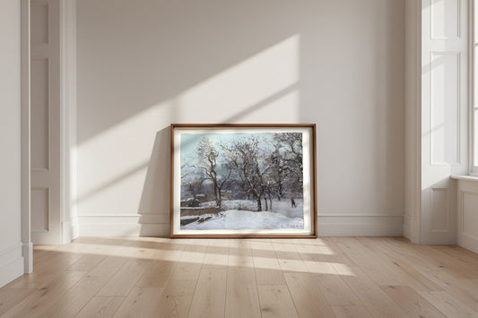 Snow at Louveciennes — Camille Pissarro Fine Art Poster shown framed and leaning against a wall in a sunlit room