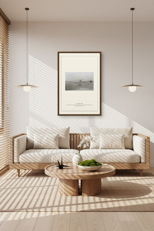 First Flight print in a sunlit room with a light wood sofa and coffee table