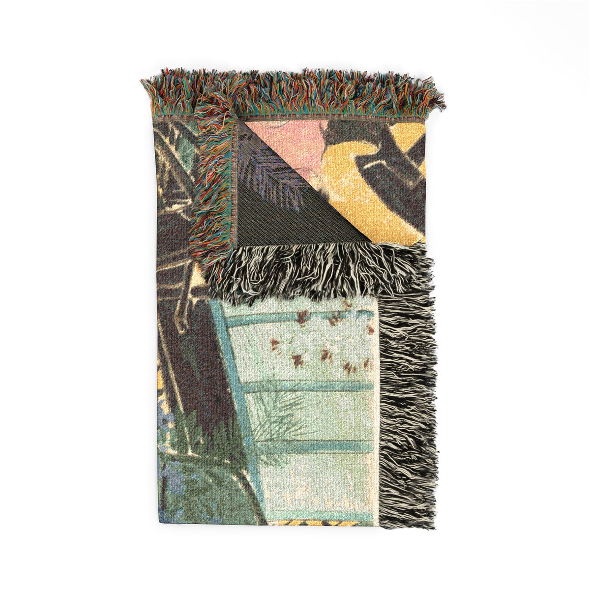 Flowers of a Hundred Worlds throw blanket folded, front cart motif visible and corner of the muted reverse with fringe