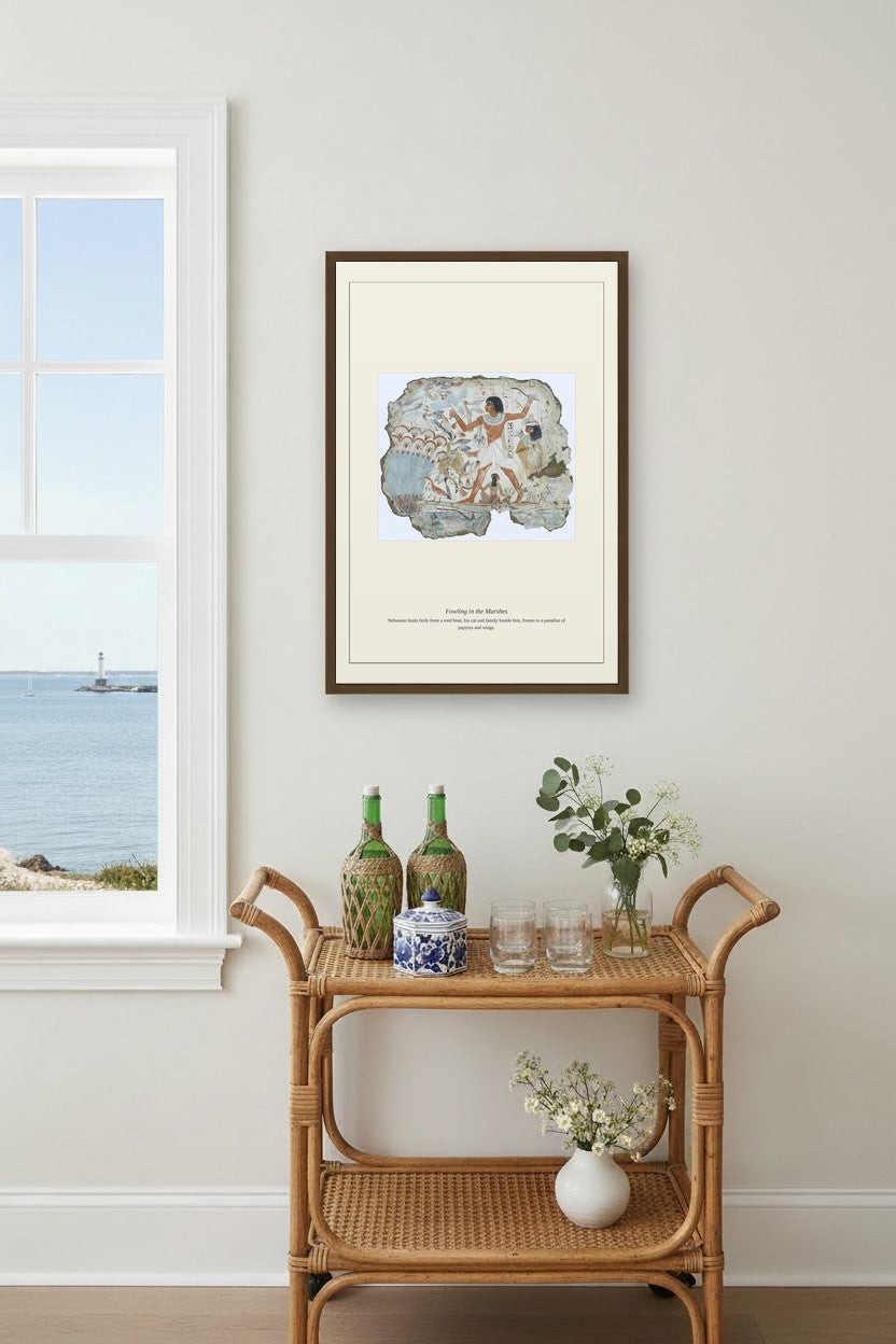 Fowling in the Marshes artwork framed above a rattan bar cart near a window with sea view