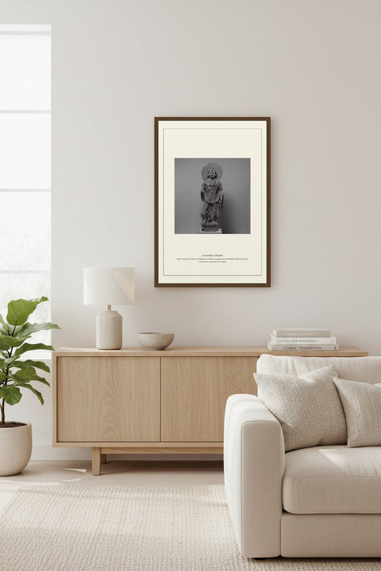 Gandhara Buddha sculpture print above a light wood sideboard beside a fiddle-leaf fig