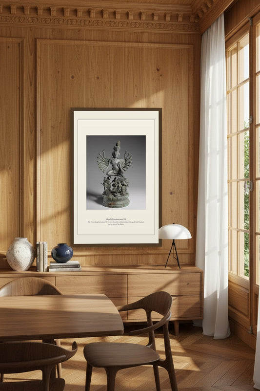 Head of Jayavarman VII framed in a wood-paneled dining room with a table lamp
