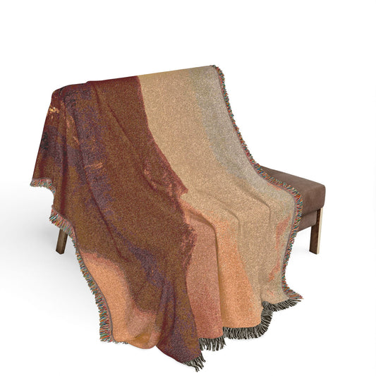 A Home in the Wilderness woven throw blanket on a bench, earthy brown mountain and warm sandy sky in landscape