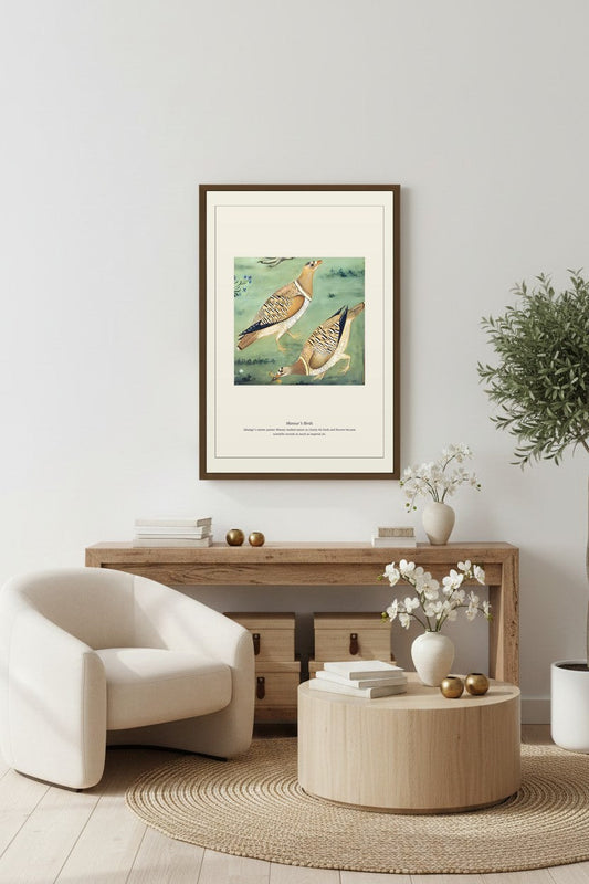 Mughal bird painting print framed above a console with white armchair
