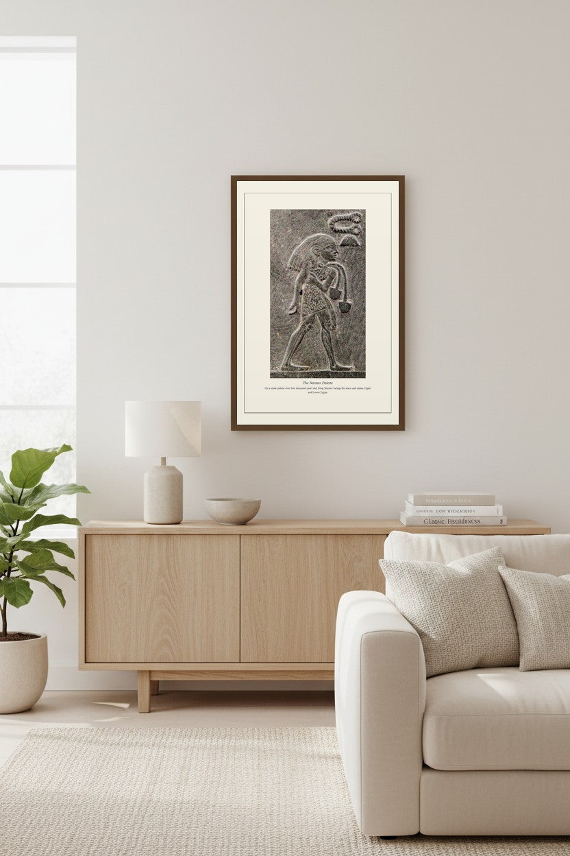 The Narmer Palette stone relief framed above a light wood sideboard beside a cream sofa
