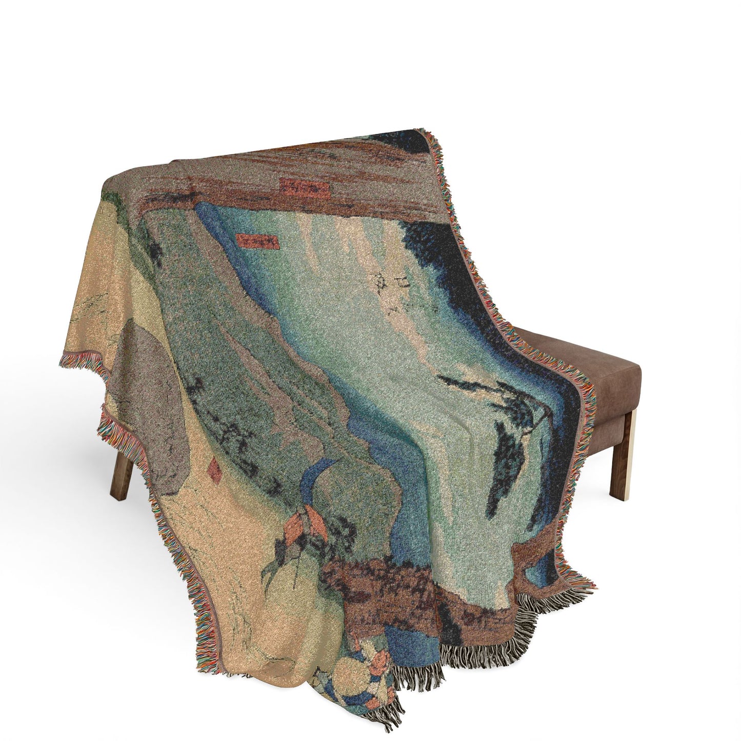 Nissaka Night-Weeping Stone throw blanket over bench, sandy ground with stone, blue-teal mountain layers, fringe cascading