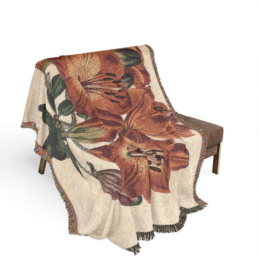 Orange-Lily Botanical blanket on wooden bench, large orange-red lily flowers and green leaves visible, cream ground, fringe