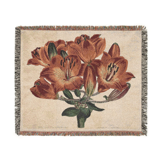 Orange-Lily Botanical woven blanket front, vibrant orange-red lily cluster with green leaves on cream background, fringe