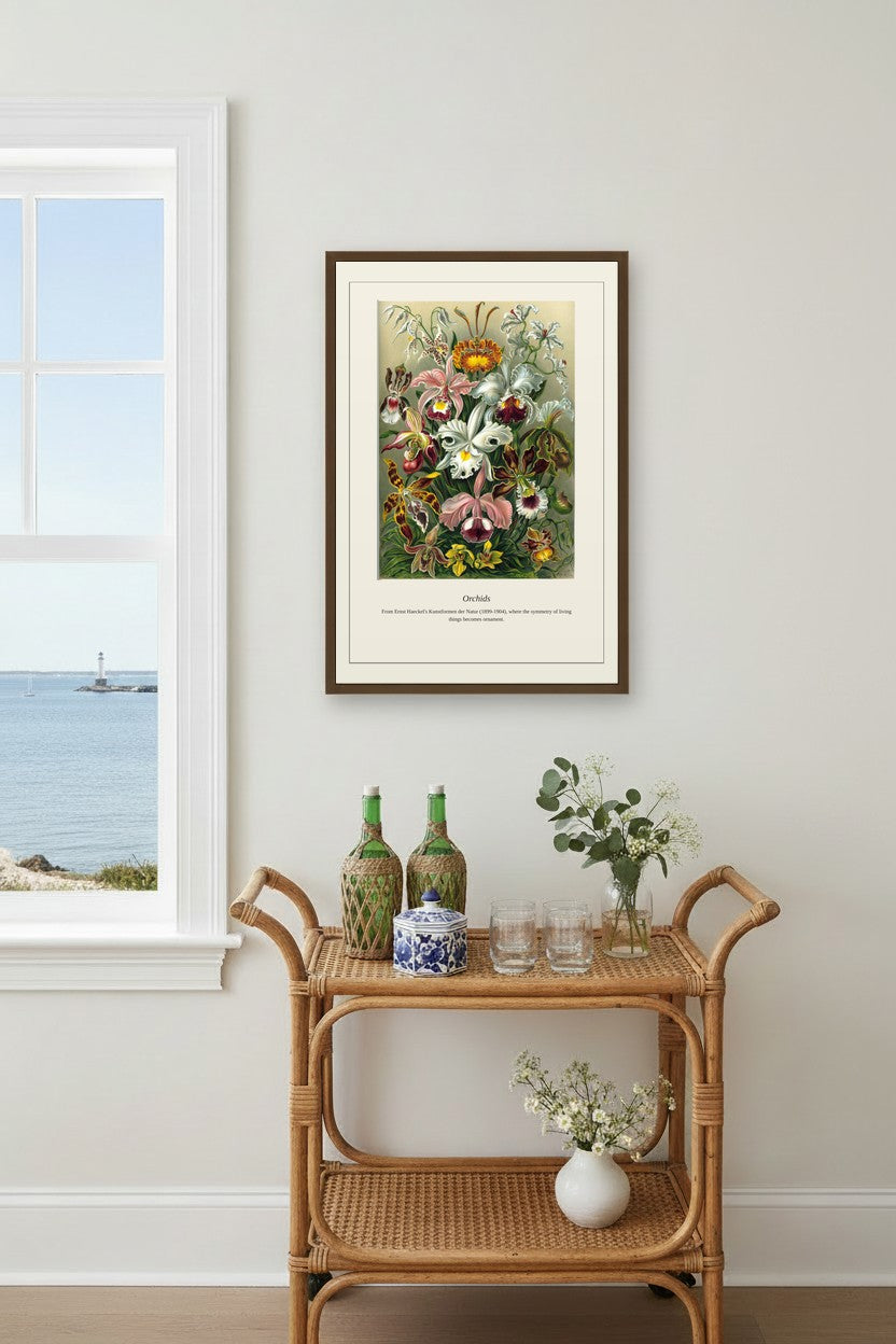 Orchids print framed above a rattan bar cart by a coastal window