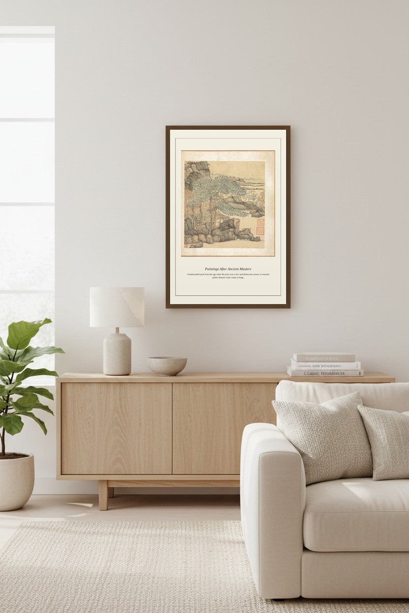 A framed art print featuring a vintage scenic illustration of the Swiss Alps, styled in a minimalist living room above a light wood sideboard.