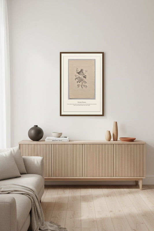 A framed vintage car poster hangs on a light gray wall above a modern wooden sideboard in a styled living room setting.