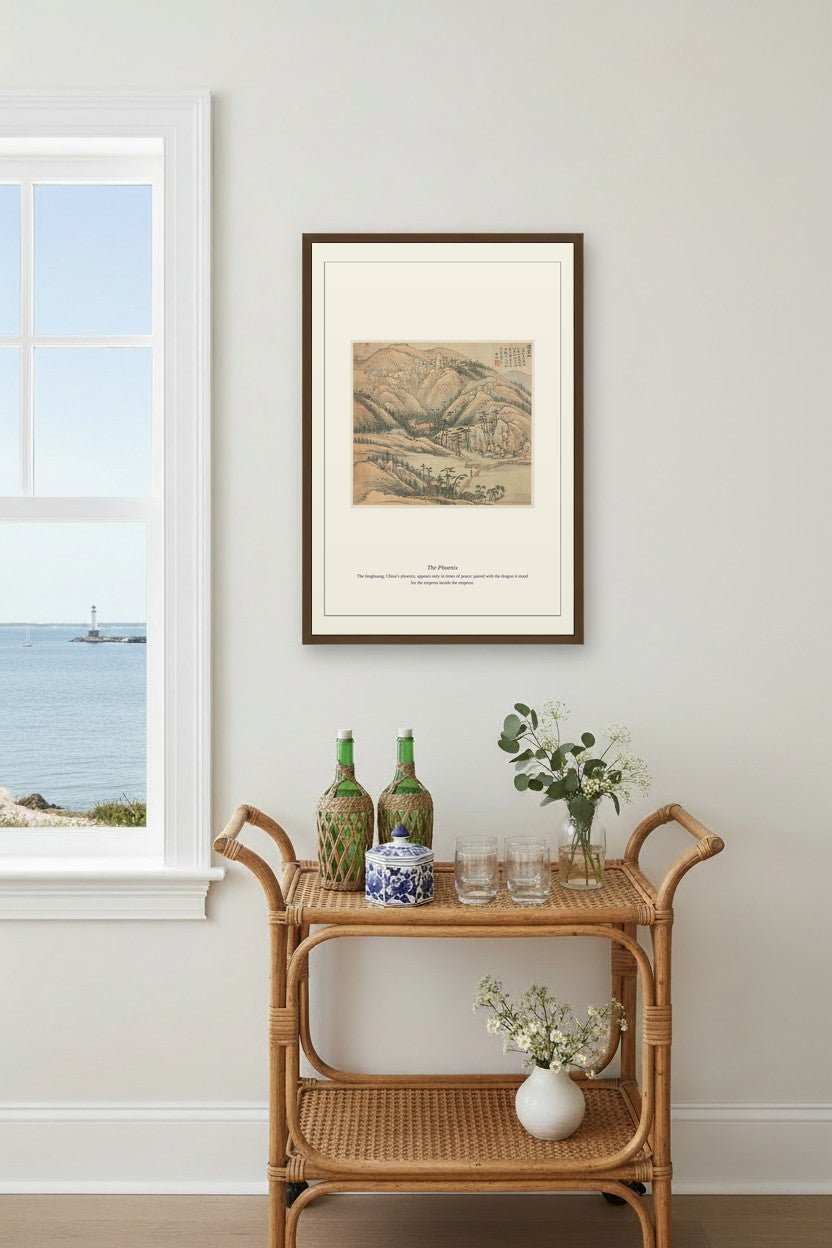 The Phoenix landscape print framed above a rattan bar cart by a coastal window