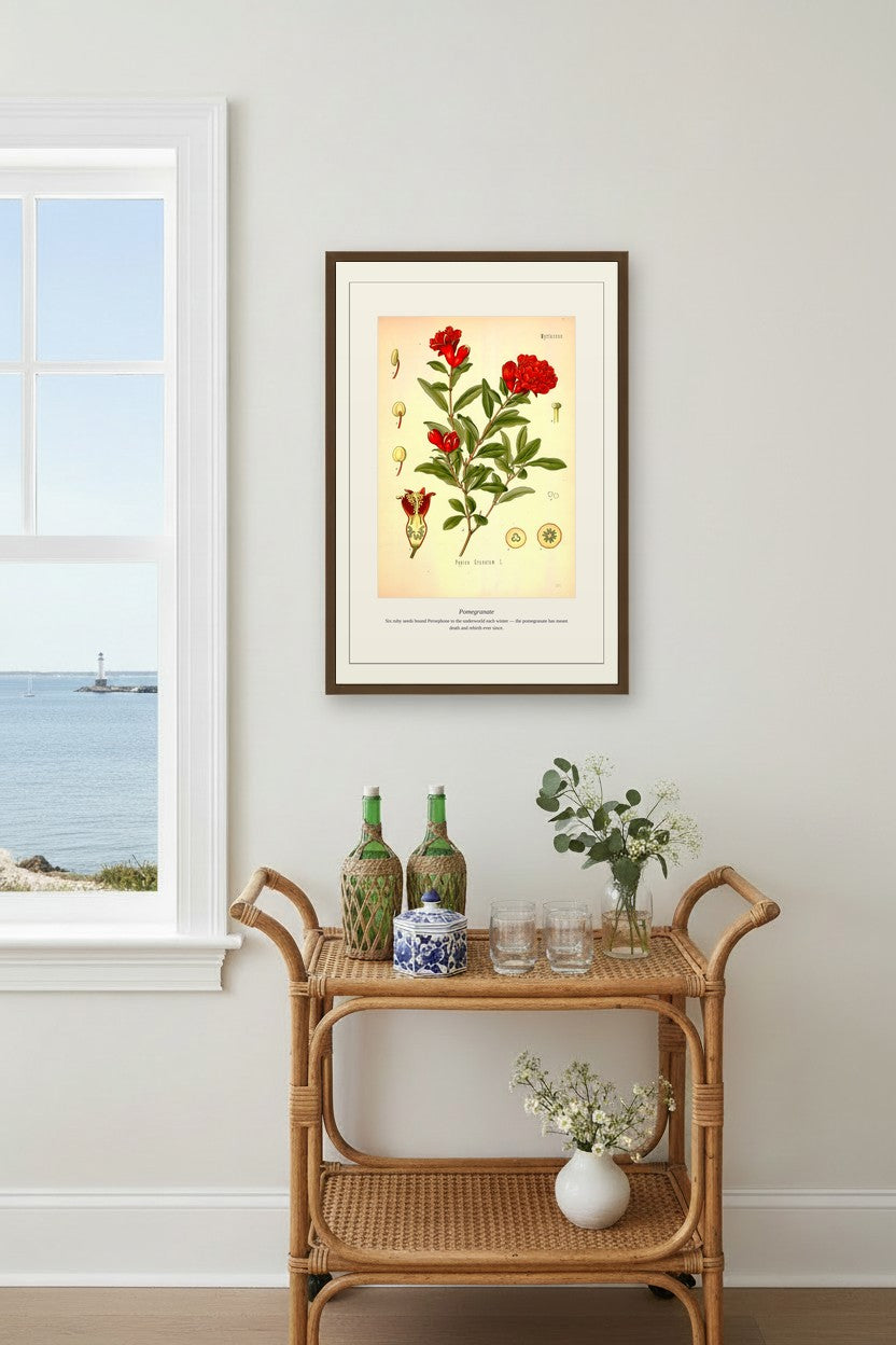 Pomegranate print above a rattan bar cart beside a coastal window view