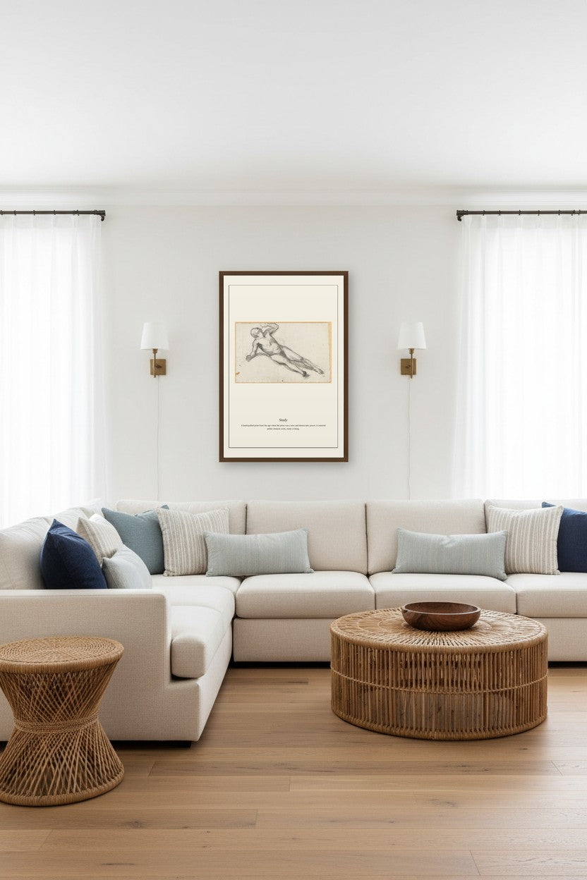 A styled living room featuring a large cream sectional sofa with blue and beige accent pillows, a round woven coffee table, a matching side table, and a framed botanical art print on the wall.