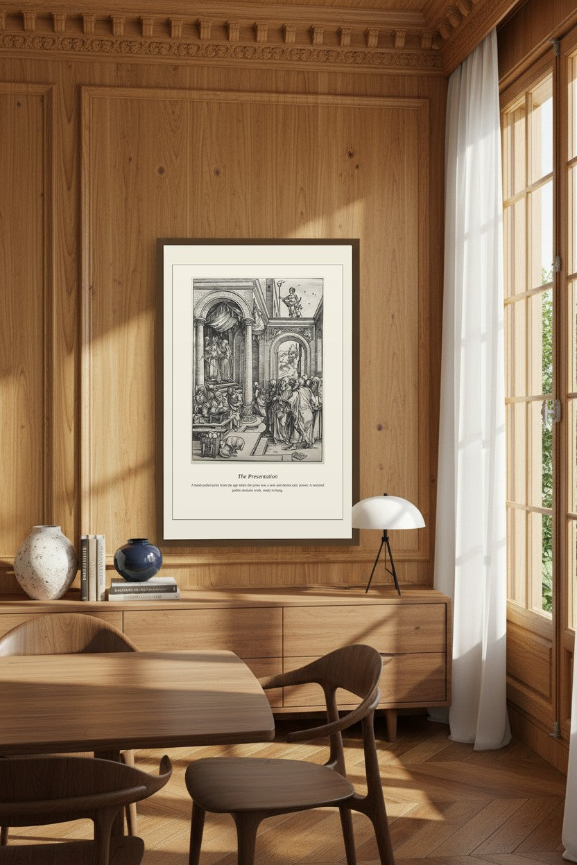 A framed black and white art print titled 'The Preparation' hangs on a wood-paneled wall in a warm, modern dining room with wooden chairs, a table, and a window with white curtains.