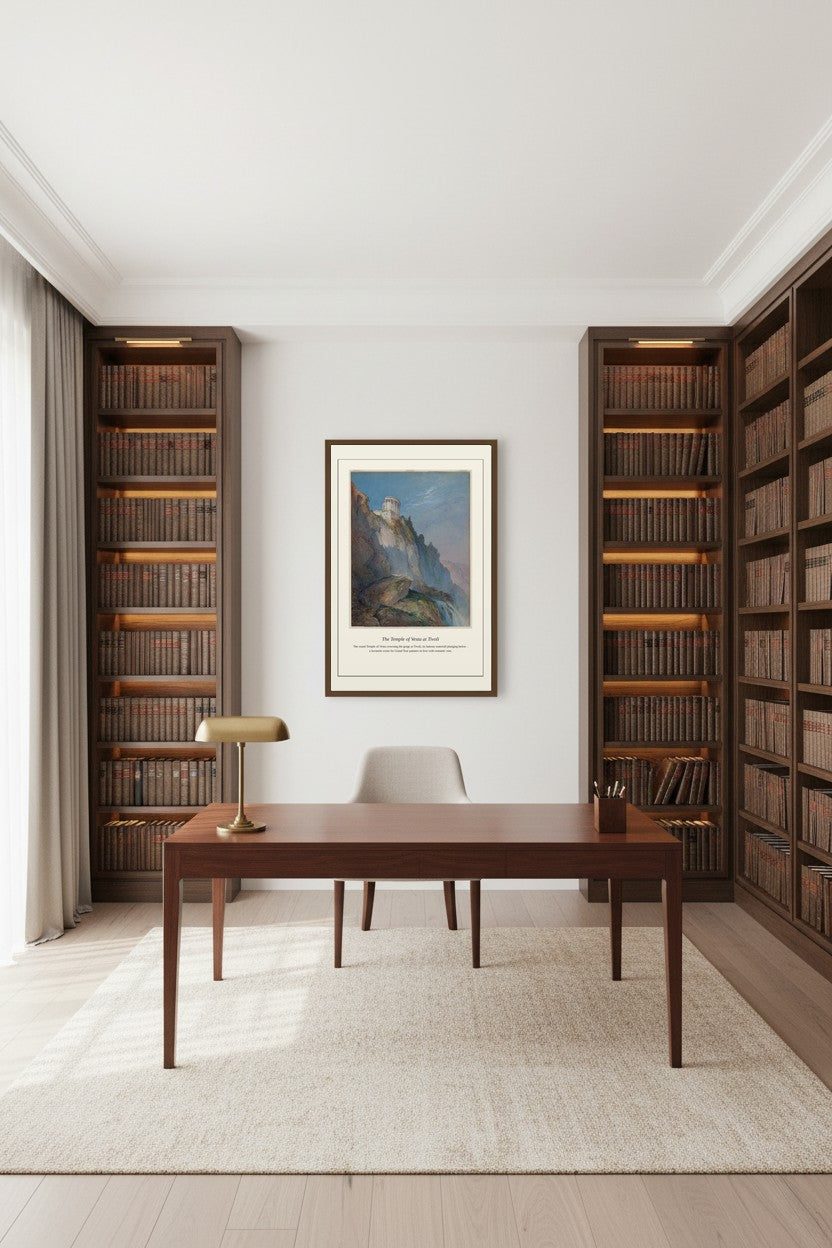 A minimalist home office featuring a dark wood writing desk, a matching chair, a brass table lamp, and a framed landscape art print on the wall. The room is flanked by tall wooden bookshelves filled with books, set on a light beige rug over light wood flooring.